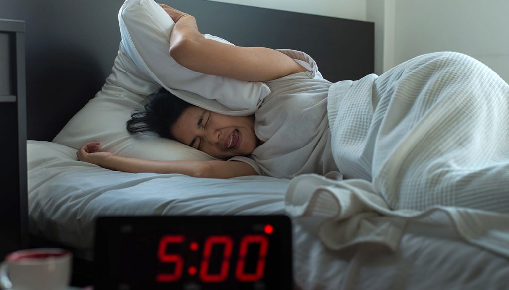 Young asian woman hates getting stressed waking up early 5 o'clock,Alarm clock